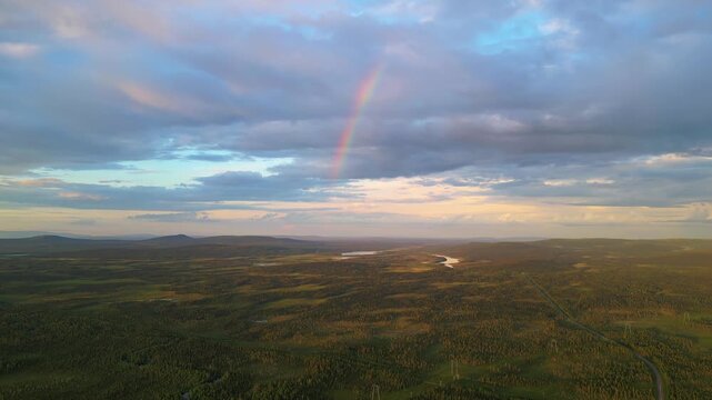 Stunning view of a landscape with Stora Lulevatten river and a rainbow in Norrbotten County, Sweden