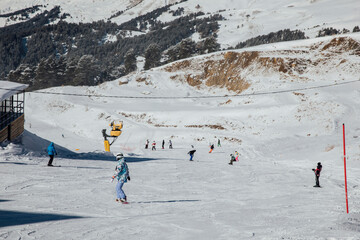 Snowboarders and skiers ski in the resort on the slopes