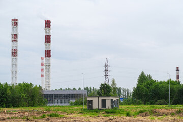 Moscow, Russia, 18.06.2025 Industrial power plant with tall red and white chimneys emitting steam. Concept of energy production and power generation.
