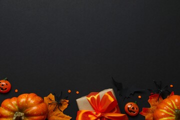 The dark ceremonial flat lay with pumpkins, gift box, bats, spiders and confetti
