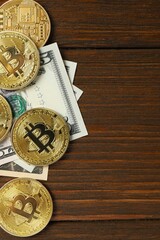 Vertical photo of of metal shiny bitcoin crypto currency coins on US dollar bills. Electronic decentralized money concept. Top view