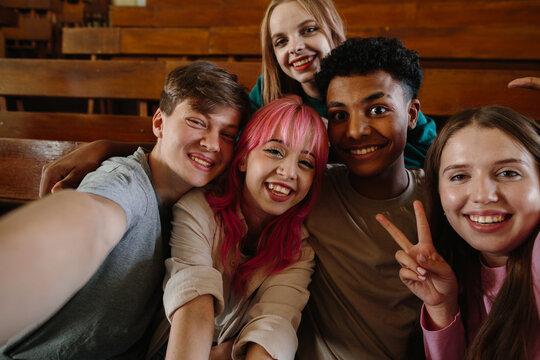 Group of Diverse Friends Smiling and Posing Together in a Classroom Setting
