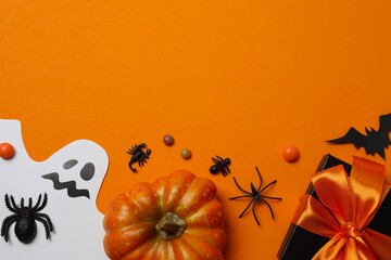 A festive Halloween arrangement with ghost, pumpkins, gift box, bat and spiders creating a spooky...