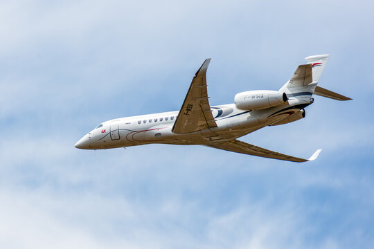 Dugny, France - June 20, 2025: Left rear view of a Falcon 6X, a large, long-range business jet developed by french manufacturer Dassault Aviation, in low altitude flight over Paris-Le Bourget airport.