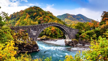 Fototapeta premium Picturesque Arched Stone Bridge Spanning a River in a Colorful Autumn Landscape