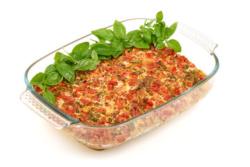 Oven-baked tomato and vegetable casserole in glass dish, isolated on white background.