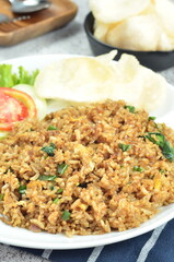 Indonesian fried rice with egg, chicken, vegetables, and crackers