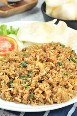 Indonesian fried rice with egg, chicken, vegetables, and crackers