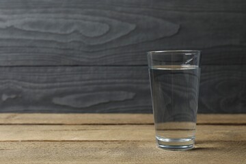Glass with water on a wooden table. Drinking clear water 