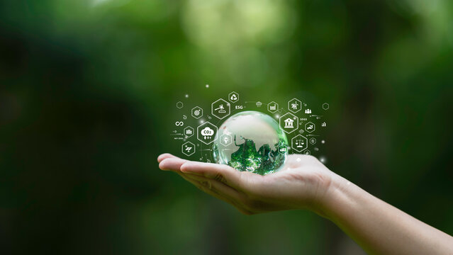 Hand holding a glass globe ESG icons of Sustainable Development, green business, circular economy, supply chain, . renewable energy, carbon emission to net zero. Earth Day  concept