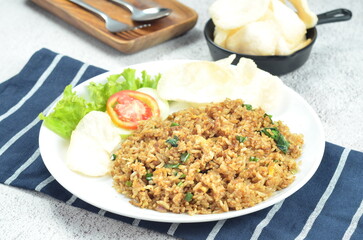 Indonesian fried rice with egg, chicken, vegetables, and crackers