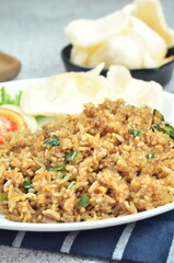 Indonesian fried rice with egg, chicken, vegetables, and crackers