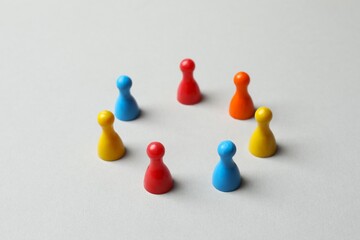 Board game figures and one another on a pastel background

