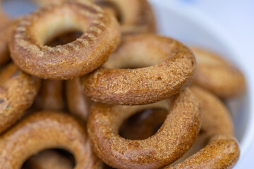 Freshly baked mini bagels on a dark background. Top view. Pretzels in the form of a ring close-up. Small bread circle biscuit. Bowls with different types of bagels.