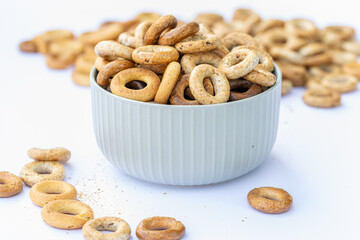 Freshly baked mini bagels on a dark background. Top view. Pretzels in the form of a ring close-up. Small bread circle biscuit. Bowls with different types of bagels.