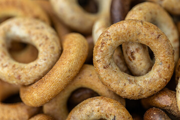 Freshly baked mini bagels on a dark background. Top view. Pretzels in the form of a ring close-up. Small bread circle biscuit. Bowls with different types of bagels.