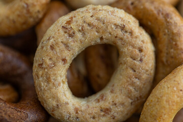 Freshly baked mini bagels on a dark background. Top view. Pretzels in the form of a ring close-up. Small bread circle biscuit. Bowls with different types of bagels.