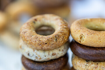 Freshly baked mini bagels on a dark background. Top view. Pretzels in the form of a ring close-up. Small bread circle biscuit. Bowls with different types of bagels.