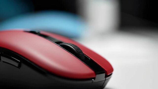 Close-up of a red computer mouse with a scroll wheel on a desk