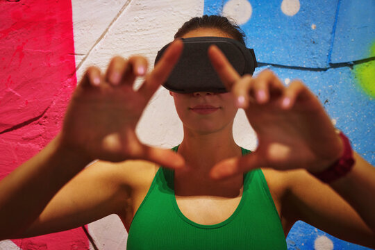 Person using VR headset with hand gestures in a colorful urban setting