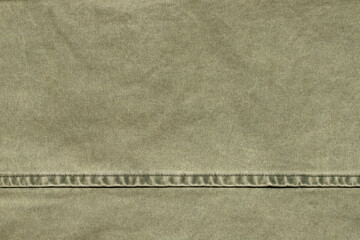 texture of green jeans denim fabric with seam background	