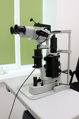Slit lamp biomicroscope used in ophthalmology for detailed examination of the eye, placed in a bright modern medical office, close-up view of the optical device