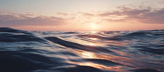 Sunset over rippling ocean waves.  Golden hues paint the sky above a calm sea