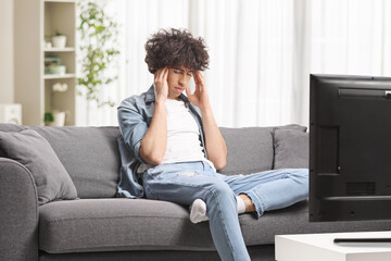 Young man on a sofa in front of tv