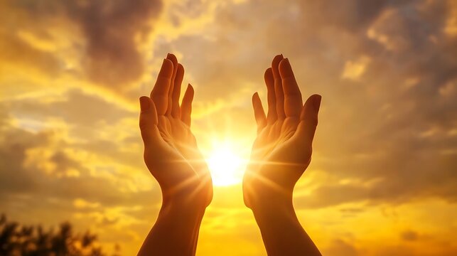 Human hands raised praying under golden sunset sky filled with faith light hope and spiritual warmth