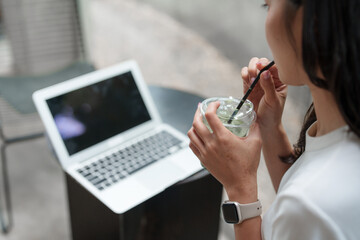Freelancer drinking matcha latte and working on laptop in cafe