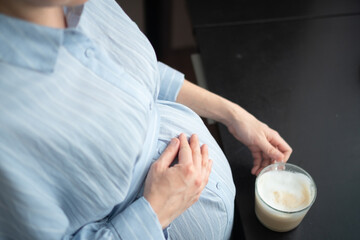 Mom-to-be savoring warm coffee drink in peaceful home setting. Responsible caffeine intake...