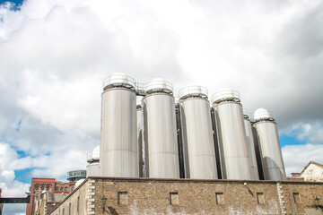 Large outdoor beer fermentation tanks with white domed tops.