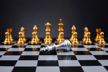 Black chess winner defeats silver king on dark background