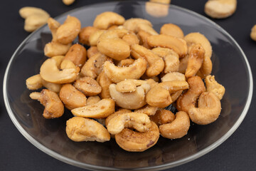 Salted cashew nuts in dessert plate on black table