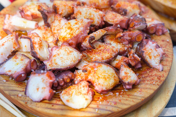 Serving fresh boiled octopus with olive oil, a gourmet seafood dish.