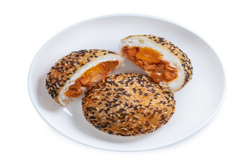 Deep-fried Chinese bun filled with BBQ pork and salted egg yolk, topped with white and red sesame seeds Asian street food snack isolated on white background with clipping path.