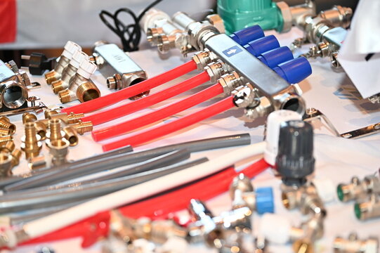 Heating manifold system and plumbing fittings with red and grey flexible pipes, brass fittings and manifold system with valves. Good for illustrating industrial catalogs, engineering brochure