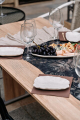 Elegant Dining Experience with Grapes and Gourmet Delicacies on a Beautifully Set Table with Glassware and Plates