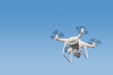 Modern RC Drone / Quadcopter with camera flying at sunrise.