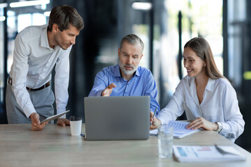 Obraz premium Group of young modern people in formalwear using modern technologies while working in the creative office