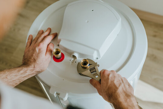 Man using a wrench to tighten a fitting on a water heater