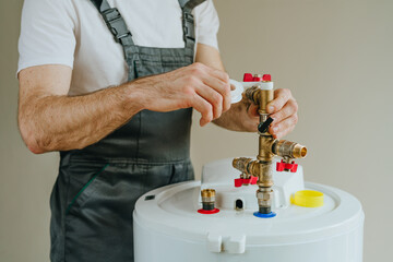 Worker wrapping plumbing tape around a fitting on a water heater