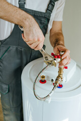 Man fixing water heater using wrench