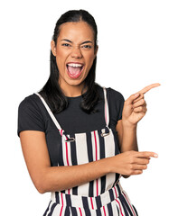 Young Filipino woman in studio pointing with forefingers to a copy space, expressing excitement and...