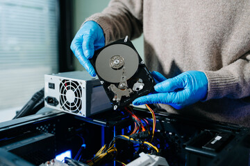  Hard disk drive on the technician's desk and a computer motherboard as a component. the concept of...