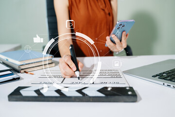 Creative woman working on tablet with digital icons and clapperboard. Modern media, marketing, and...