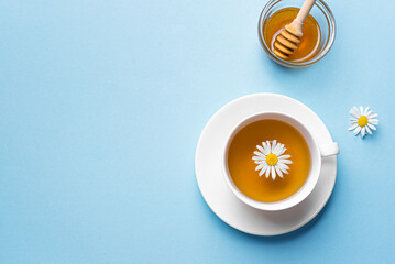 Chamomile tea cup with honey and chamomile flowers