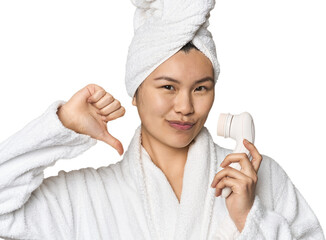 Chinese woman with electric facial cleanser feels proud and self confident, example to follow.
