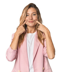 Young blonde in stylish pink suit doubting between two options.
