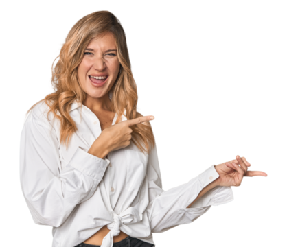 Caucasian blonde woman in studio pointing with forefingers to a copy space, expressing excitement and desire.